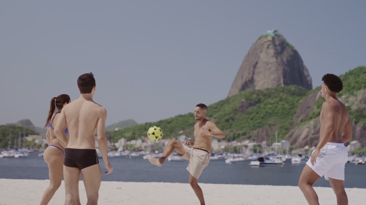 Friends playing beach soccer with Sugarloaf Mountain in the background