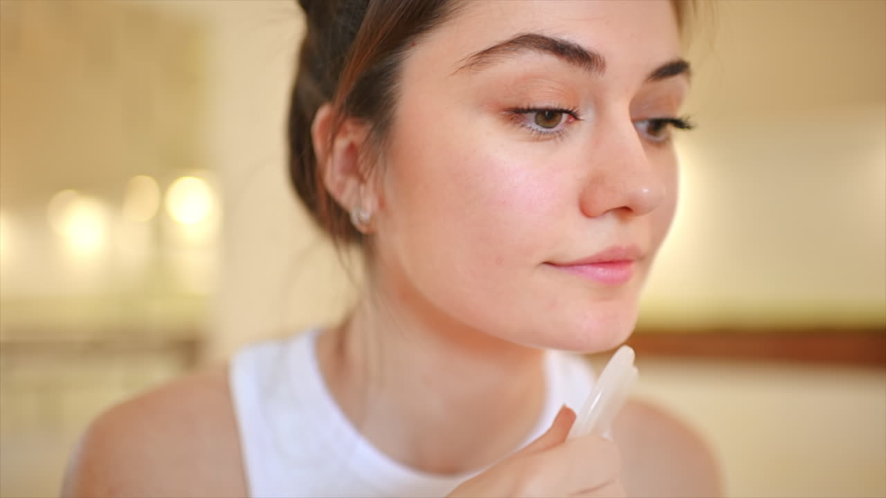 Woman using gua sha for facial massage