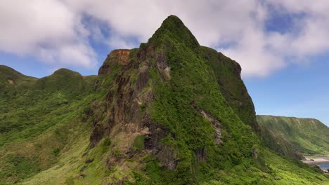 aerial orbiting shot of green mountains on orchid island with shadow of clouds - idyllic natural landscape