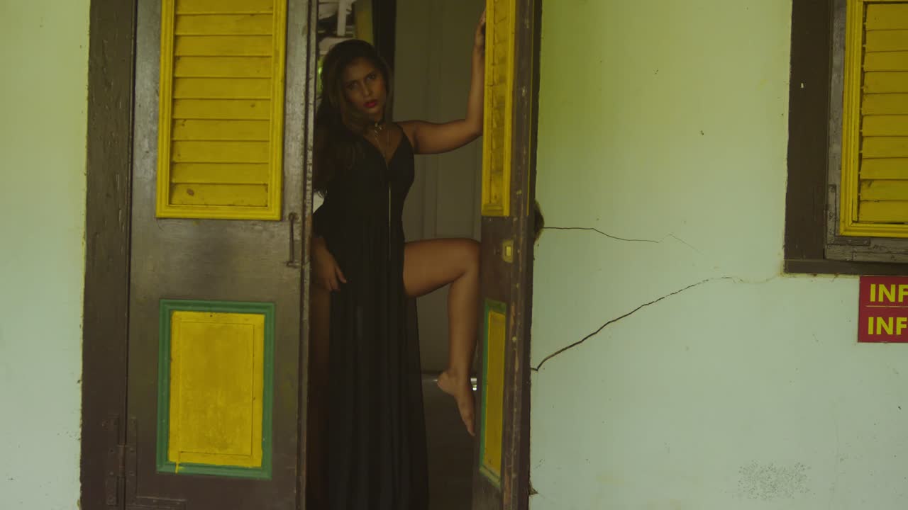 At a historical complex, a young girl in a black dress stands quietly.