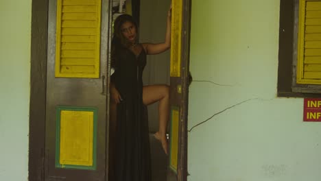 at a historical complex, a young girl in a black dress stands quietly.