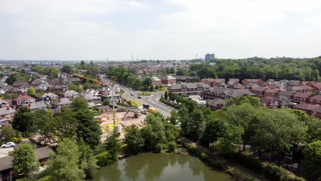 lakeside red brick british townhouse building site aerial view panning across detached neighbourhood property