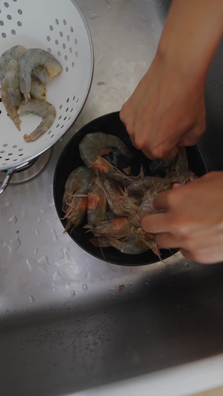 Hands Cleaning Shrimp in a Kitchen Sink