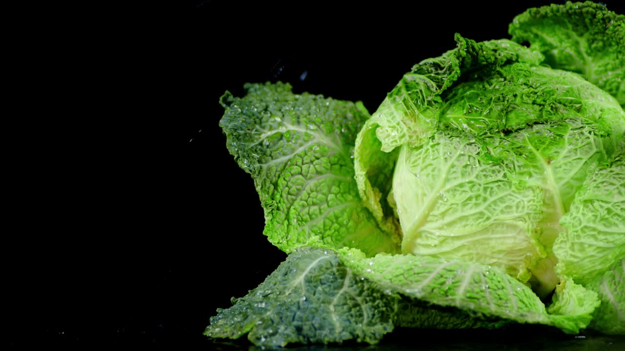 gotas de agua cayendo sobre el repollo de horquillas verdes frescas.
