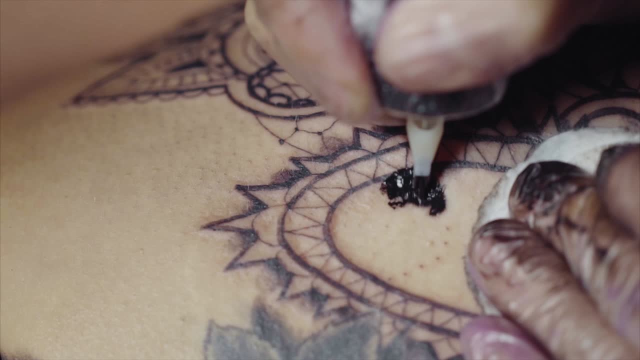 Tattoo Artist Applying Ink to a Mandala Design