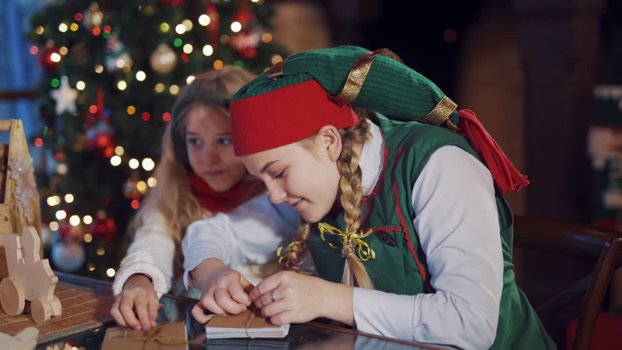 Child and elf with letters. Child preparing for Santa Claus letters in residence