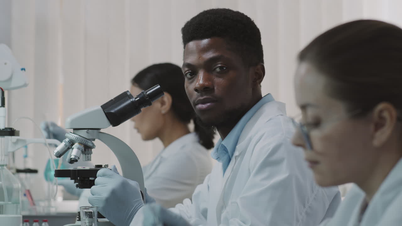 Scienziato afroamericano di sesso maschile guarda la fotocamera