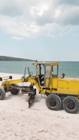 yellow sand-moving machine on beach