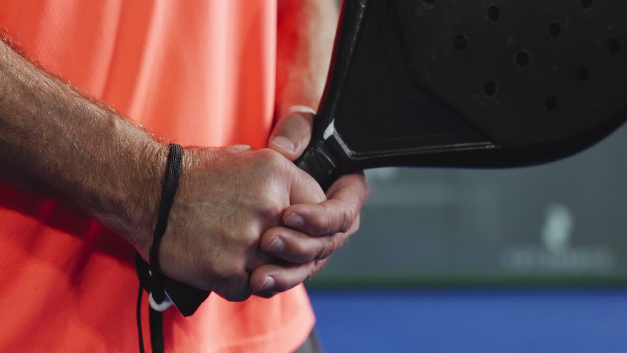 Nahaufnahme von Händen, die einen Padel-Schläger halten