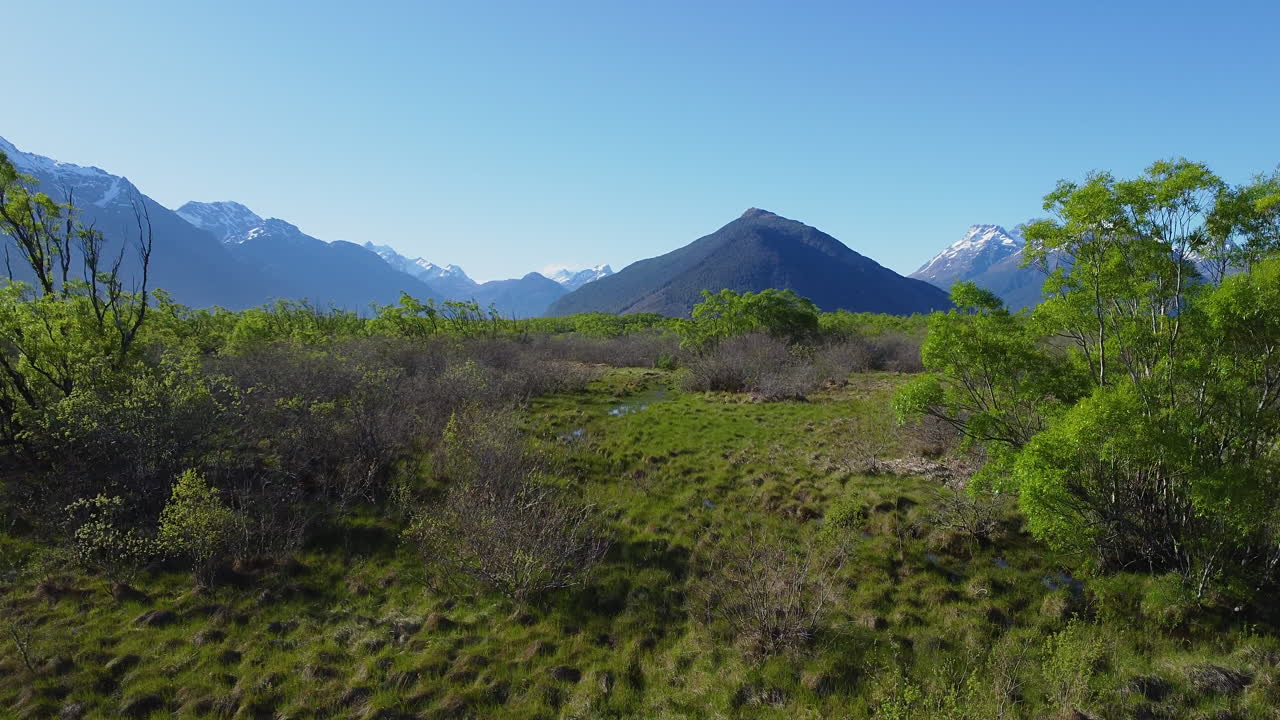 volando a través de la pasarela escénica de la laguna de glenorchy con pantanos y montañas en glenorchy, nueva zelanda