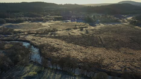 La-Luz-Del-Sol-Al-Final-De-La-Tarde-Proyecta-Sombras-Sobre-Un-Campo-Vacío-Con-Una-Toma-Aérea-De-Drones-En-La-Aldea-De-Aberfoyle-En-Escocia.