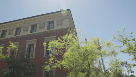 edificios icónicos de madrid con ventanas y árboles en primer plano, órbita de movimiento