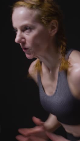 Vertical-Video-Studio-Shot-Of-Mature-Women-Wearing-Gym-Fitness-Clothing-Doing-Cardio-Exercise-Running-On-The-Spot