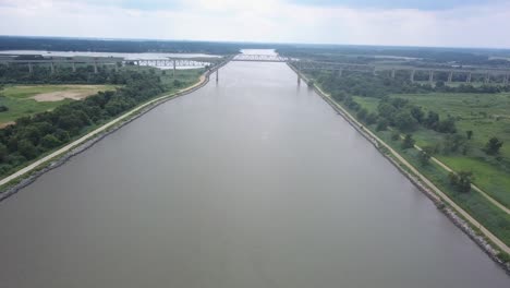 drone volando alrededor de un puente fluvial en delaware en un día nublado brillante