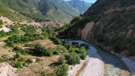 river streaming through narrow valley between mountains and lush vegetation in albania