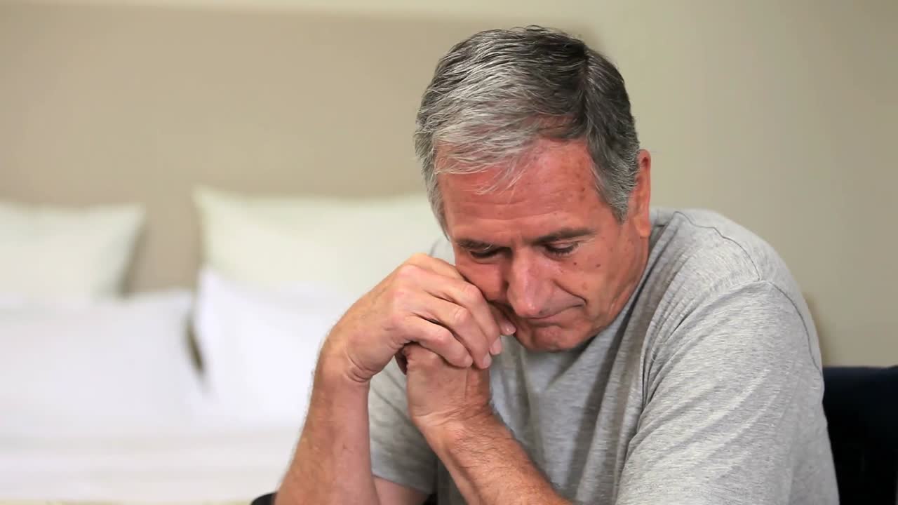 hombre infeliz mirando por la ventana