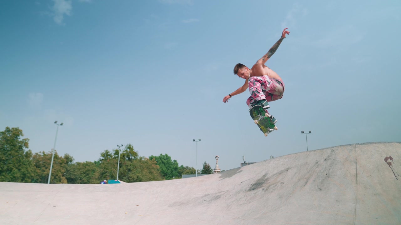 Giovane uomo che esegue un trick aereo con lo skateboard al rallentatore