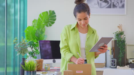 Woman-With-Digital-Tablet-Running-Online-Business-From-Home-Packing-Boutique-Candles-For-Shipping