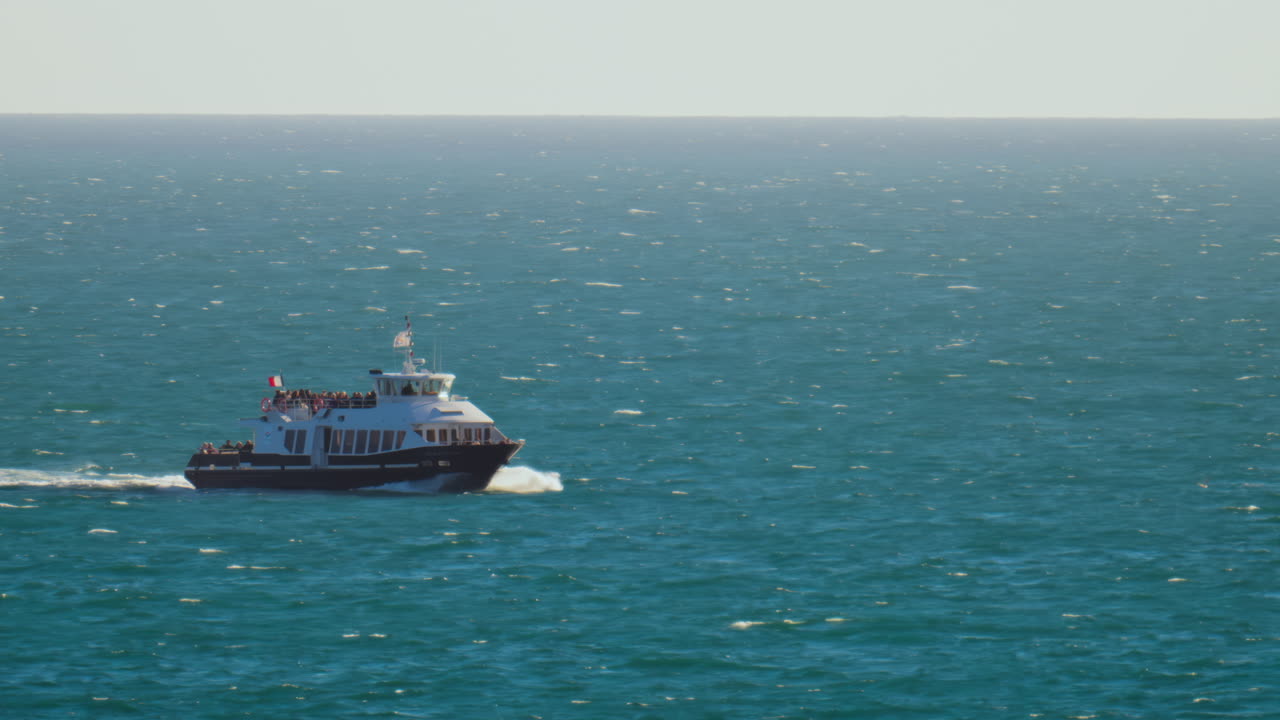 Boat filled with people moving on the sea on a sunny day
