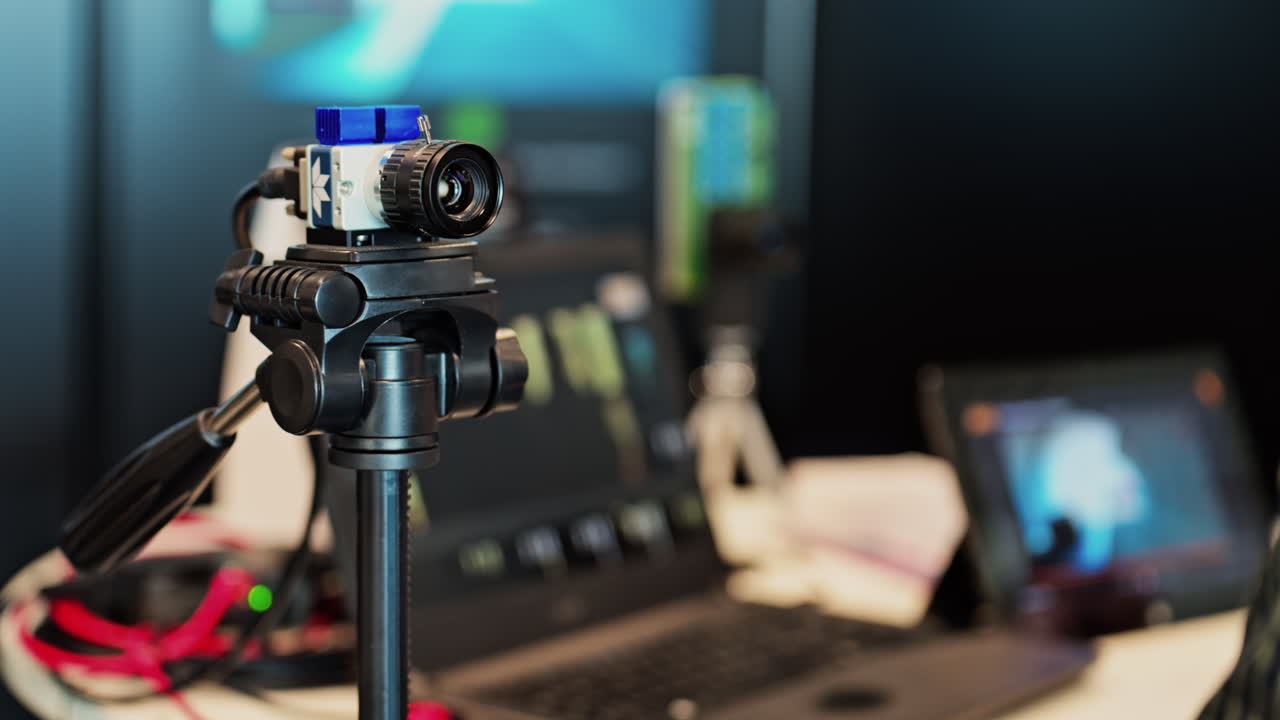 Close up of a professional camera filming on a tripod on a blurred background