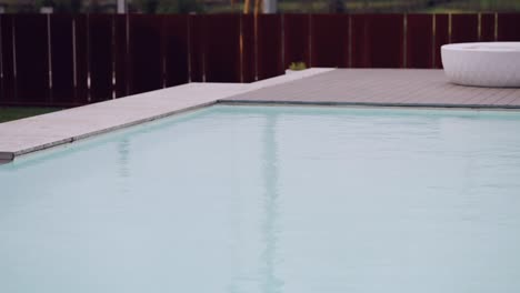 tranquil poolside ambiance, reflecting sky on water, edged by a sleek design