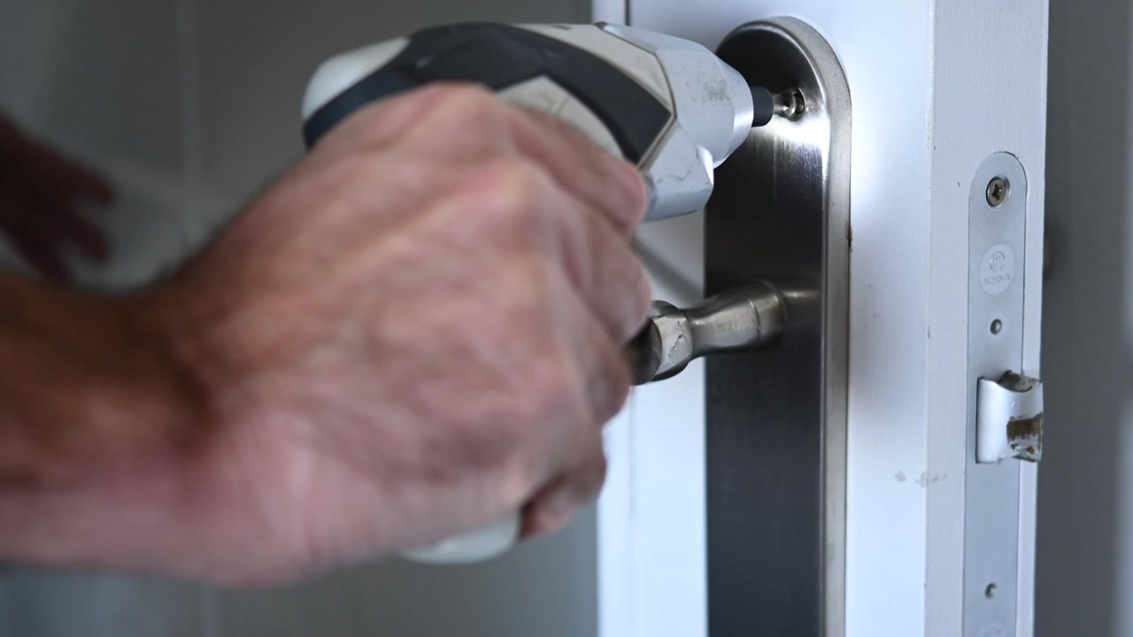 Primo piano di un avvitatore a batteria senza fili che avvita una vite per maniglia