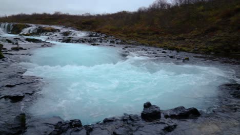 toma panorámica de agua que fluye en la cascada de bruarfoss en islandia durante las nubes en el cielo