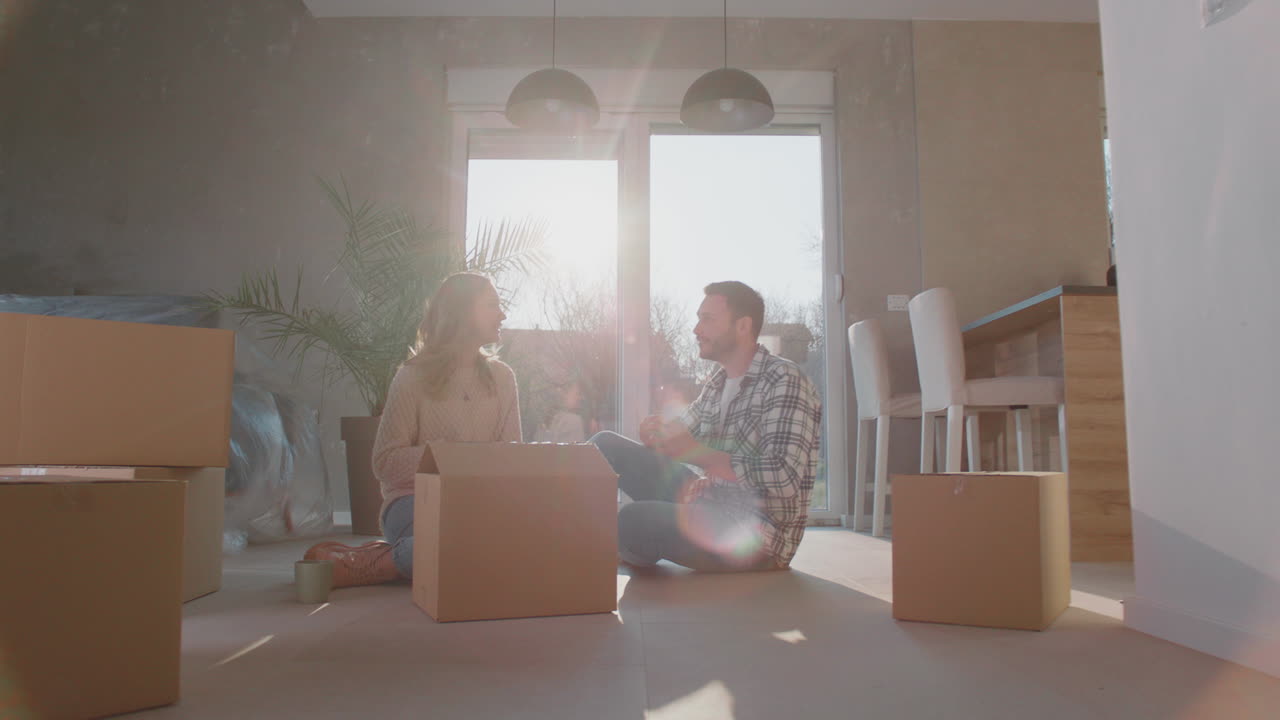 상자 들 과 함께 바닥 에 앉아 있는 부부