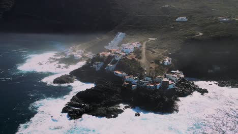 Dando-Vueltas-Estableciendo-Una-Toma-Aérea-De-Un-Pequeño-Pueblo-En-Un-Acantilado-Costero,-Tenerife-España