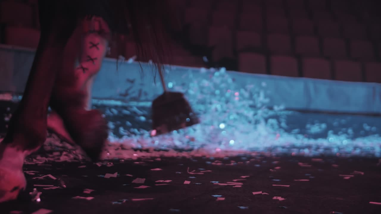 девушка подметает конфеты на цирковой арене, перед ходячими лошадьми, красивое освещение, замедленное движение