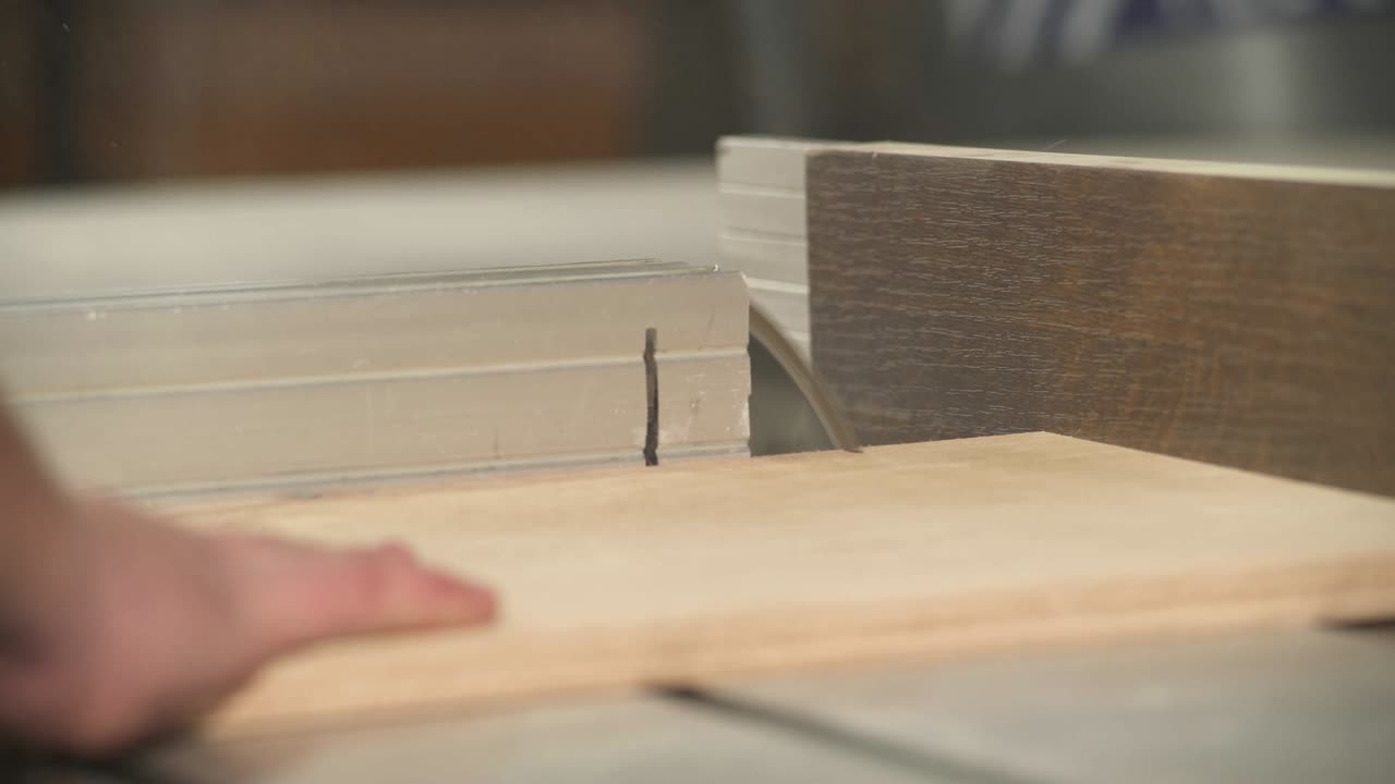 A side view of a table circular saw making a cross-cut of a plywood board