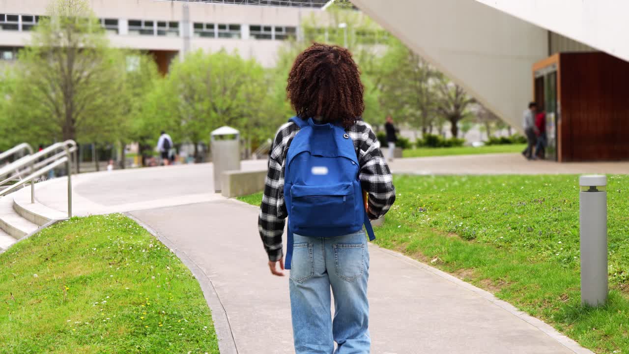 Student walking on campus with backpack