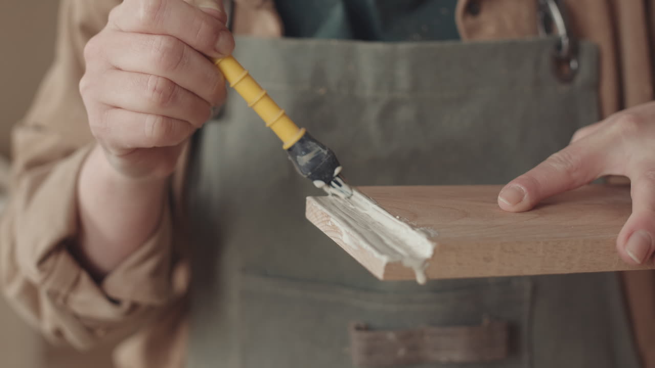 Professional Joiner Applying Glue on Plank
