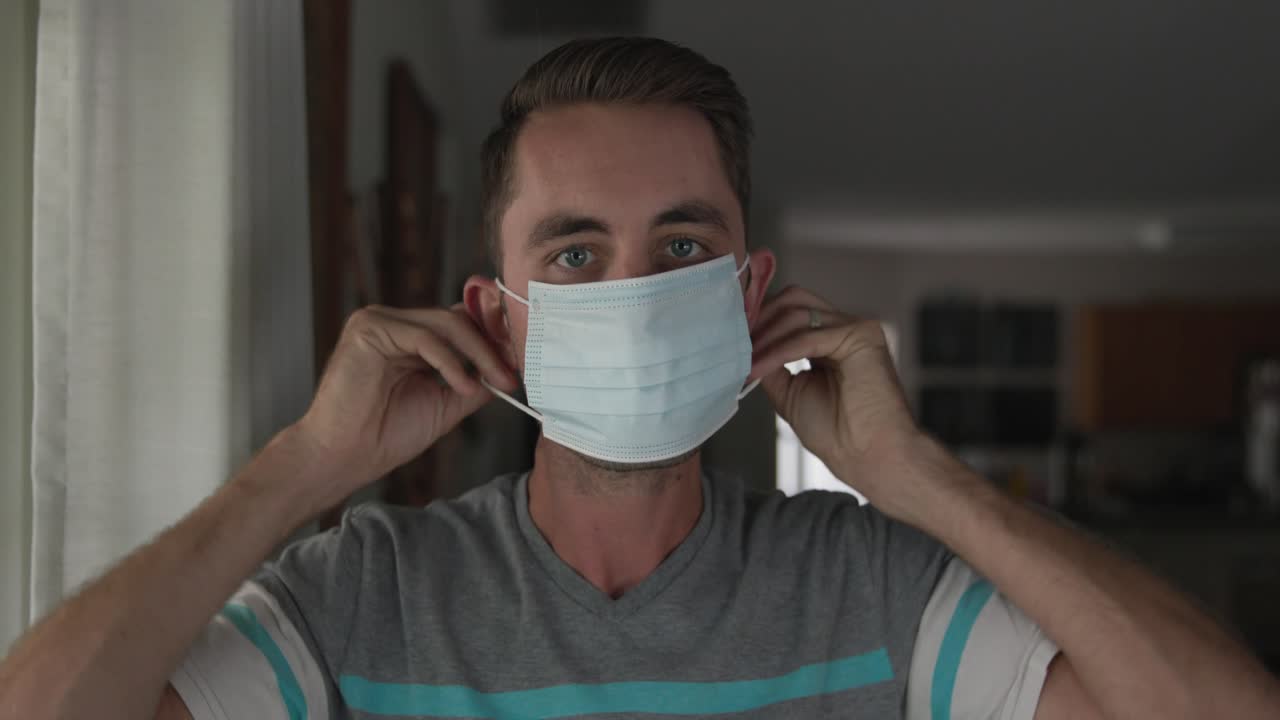 joven poniéndose una máscara pandémica covid