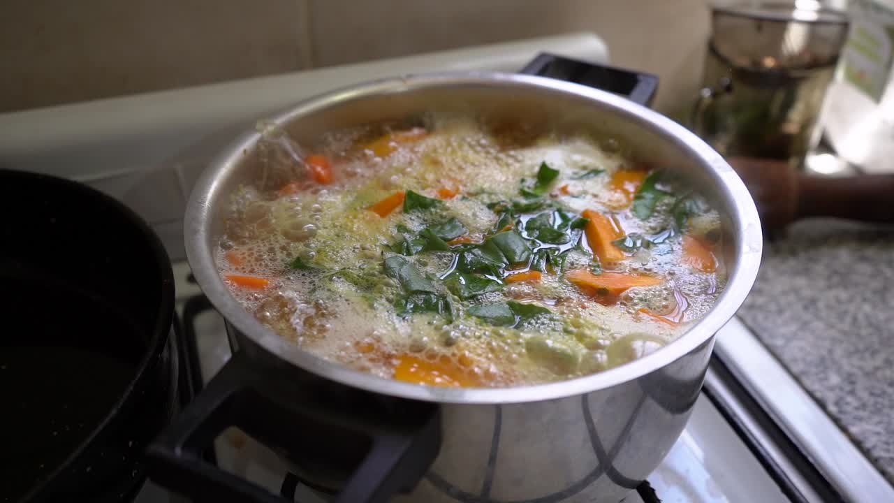 sopa de verduras caliente hirviendo y cocinando en una olla sobre la estufa