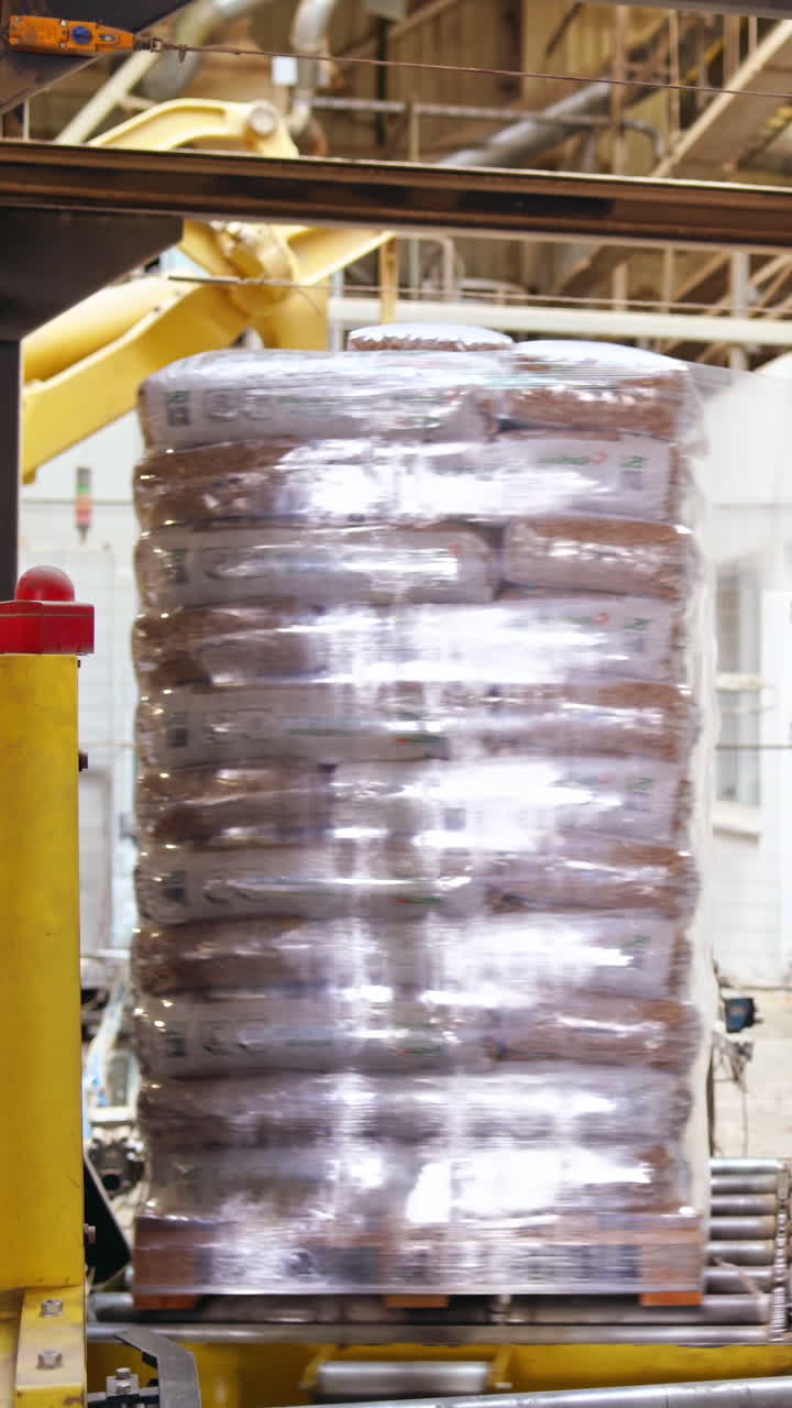 Shipping boxes wrapped in plastic shrink. Goods on a wooden pallet. Vertical video