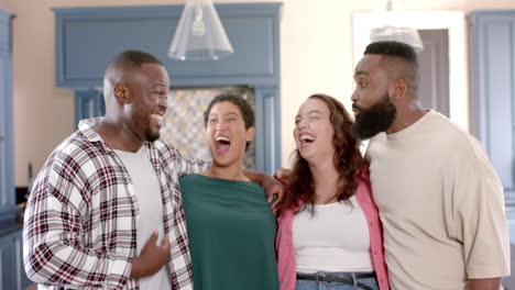 diverse friends laughing and hugging, enjoying time together at home in kitchen