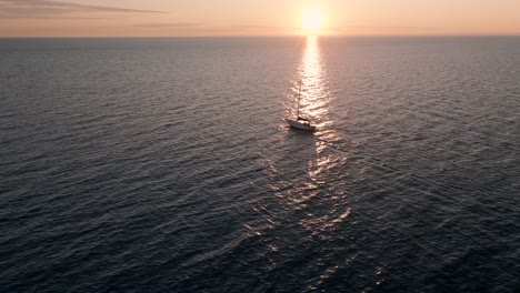 a lone sailboat cruising on the open waters of saint lawrence with a scenic view of sky on a sunrise in quebec, canada