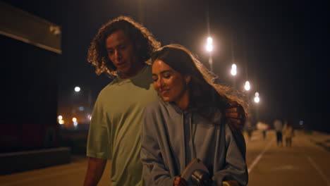 teen lovers walking evening promenade closeup. skaters couple stepping road