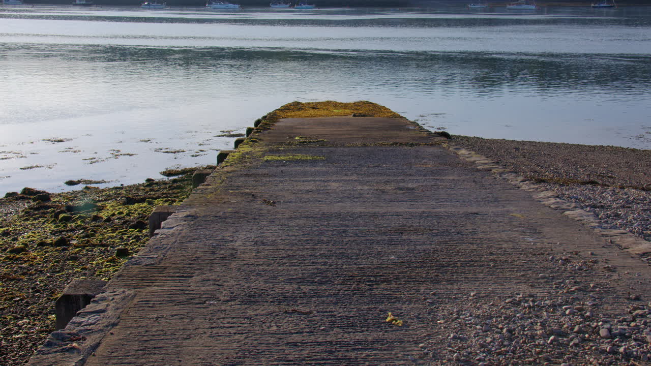 Wide shot looking down a concrete slipway low tide on the Menal Strait at Moel Y Don, Llanfairpwllgwyngyll