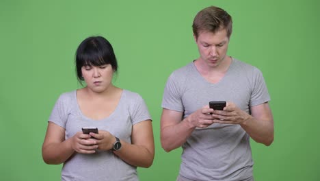 young happy multi-ethnic couple using phone together