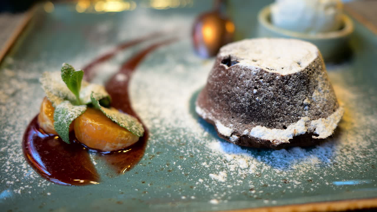 Chocolate lava cake with ice cream and orange decoration in a restaurant