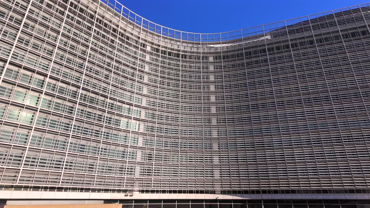 Berlaymont Building with EU flags waving at the end of the shot