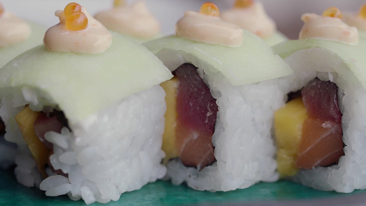 Close-up of Fresh Sushi Rolls with Tuna, Salmon, Mango, and Cucumber