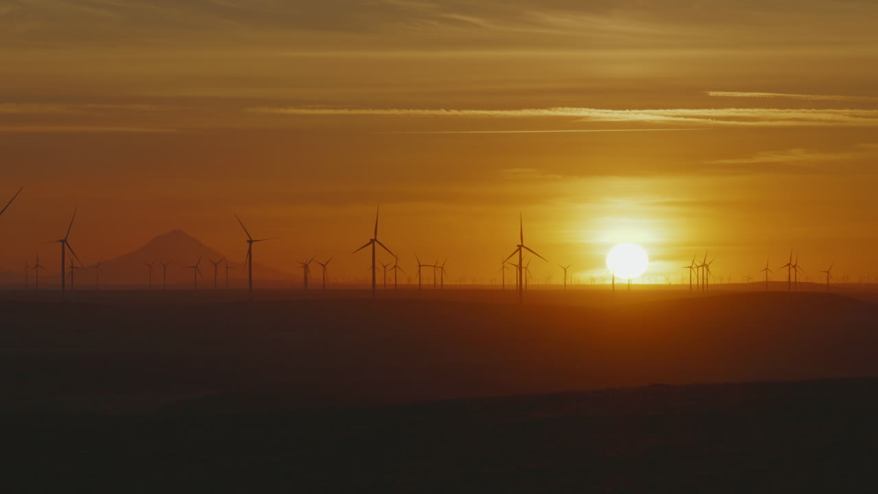 Picturesque Sunset In Oregon With Scenery Of Spinning Wind Turbines In Silhouette At The Field Near Mount Hood. wide