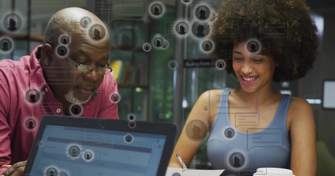 Senior mentor leaning to laptop, mentee reviewing docs causing UI icons overlaying education