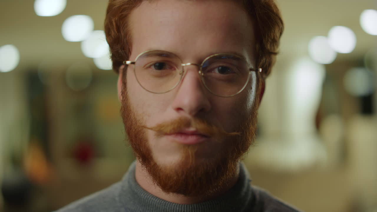 Businessman looking at camera in office. Male hipster wearing stylish eyeglasses
