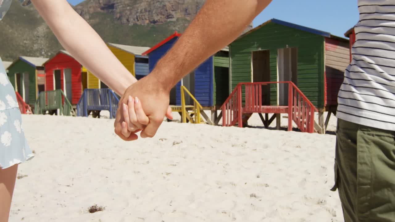 pareja caminando de la mano en la playa 4k