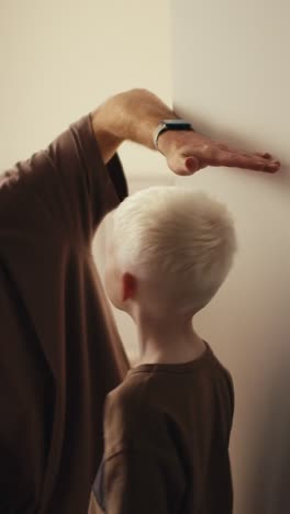 Father and son measuring and grooming
