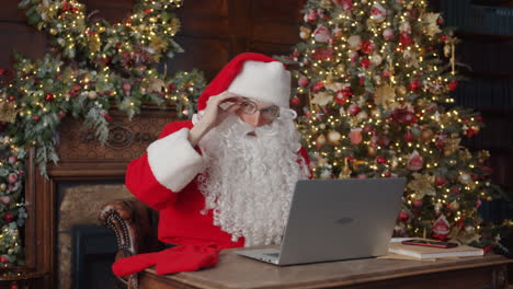 santa claus working on laptop during christmas